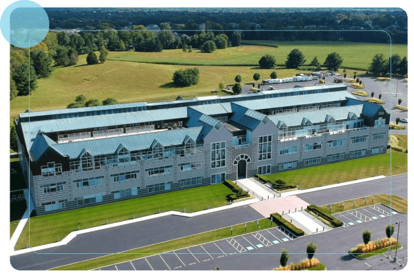 An aerial view of a building with a parking lot in the foreground.